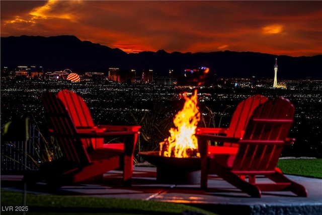 patio terrace at dusk with a mountain view and an outdoor fire pit