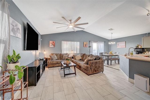 living room featuring ceiling fan with notable chandelier and vaulted ceiling