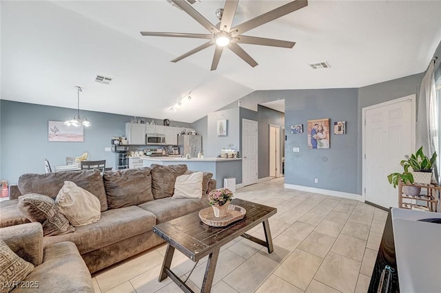 living room featuring vaulted ceiling and ceiling fan with notable chandelier