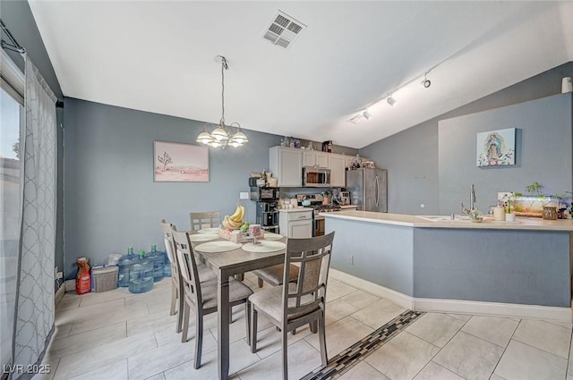 dining room with light tile patterned flooring, lofted ceiling, sink, and a notable chandelier