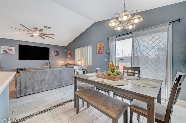 dining space featuring lofted ceiling and ceiling fan with notable chandelier