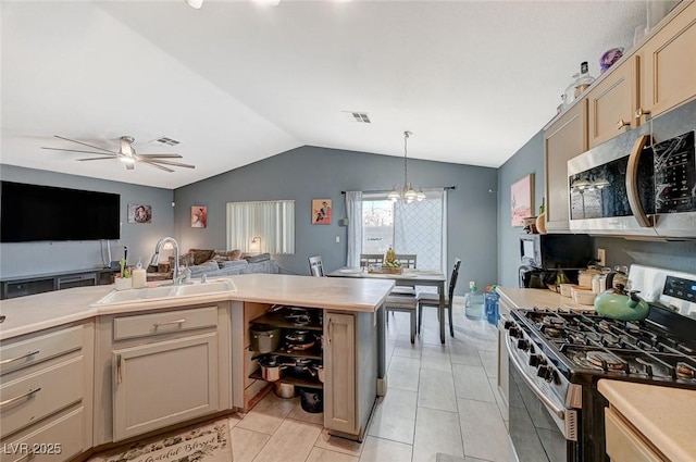 kitchen with pendant lighting, sink, stainless steel appliances, ceiling fan with notable chandelier, and vaulted ceiling