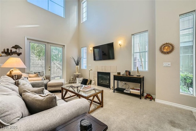 carpeted living room with plenty of natural light, a high ceiling, and french doors