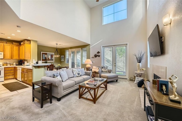 living room featuring french doors, a high ceiling, and light colored carpet