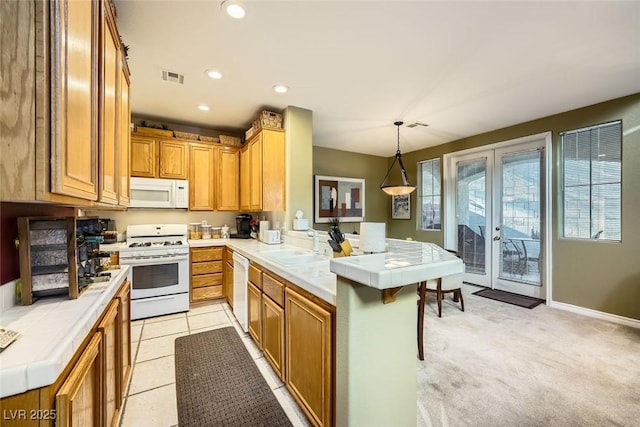 kitchen featuring kitchen peninsula, white appliances, tile countertops, and decorative light fixtures