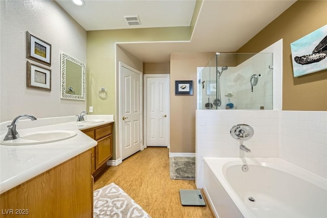 bathroom featuring hardwood / wood-style floors, shower with separate bathtub, and vanity