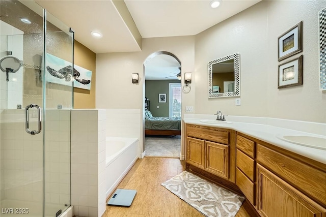 bathroom featuring hardwood / wood-style flooring, vanity, ceiling fan, and shower with separate bathtub