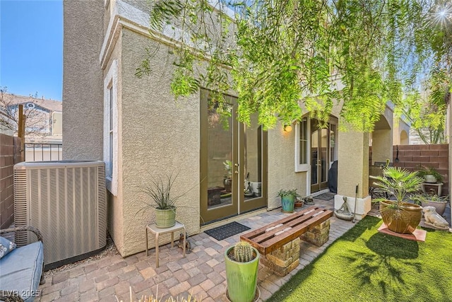 rear view of property featuring a patio area, cooling unit, and french doors