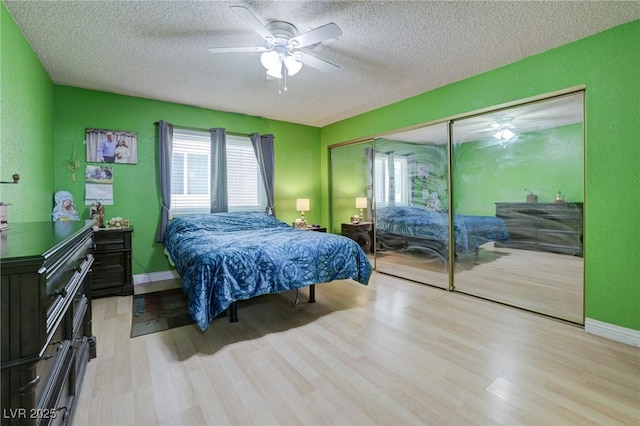 bedroom with ceiling fan, a closet, multiple windows, and a textured ceiling