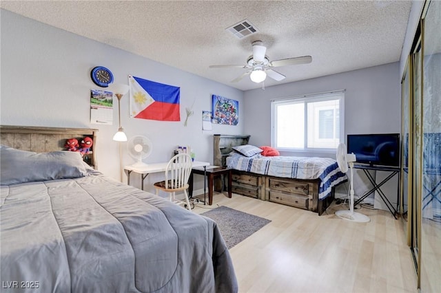 bedroom featuring a textured ceiling, ceiling fan, and hardwood / wood-style flooring