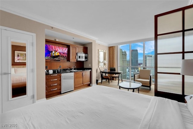 bedroom featuring ornamental molding, floor to ceiling windows, and indoor wet bar