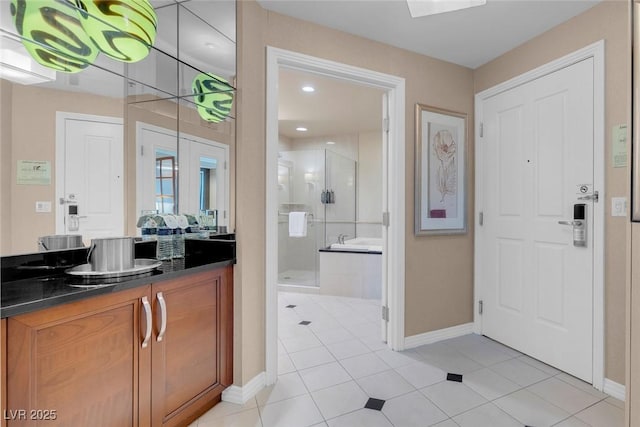 bathroom featuring vanity, a shower with shower door, and tile patterned flooring