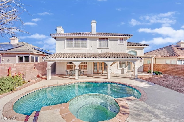 back of house featuring a pool with hot tub and a patio area