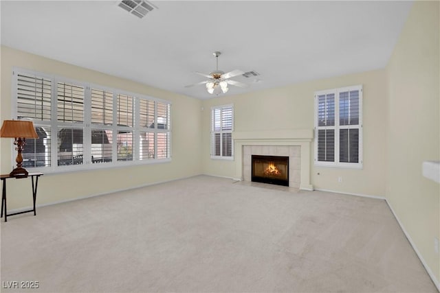 unfurnished living room with ceiling fan, light carpet, and a fireplace