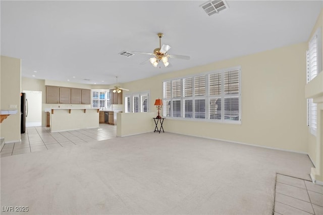 unfurnished living room featuring light colored carpet and ceiling fan