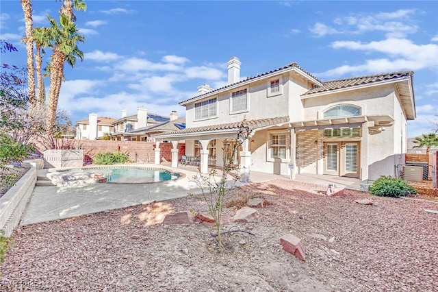 rear view of house with a fenced in pool, a pergola, and a patio area