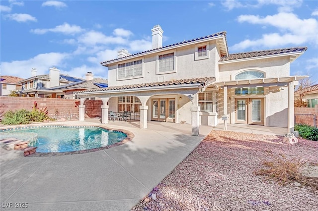 back of house with a fenced in pool, a patio, and french doors