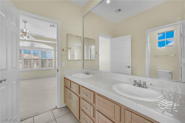 bathroom featuring tile patterned flooring, vanity, ceiling fan, and toilet