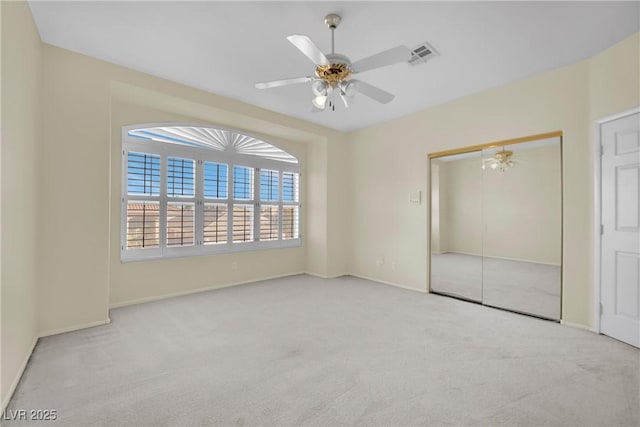 unfurnished bedroom with light carpet, ceiling fan, and a closet