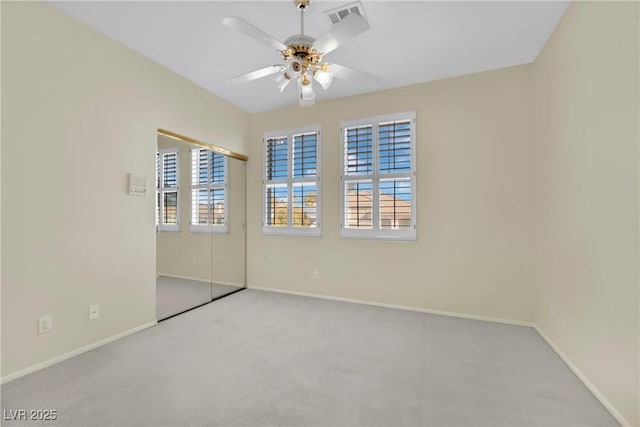 empty room featuring ceiling fan, plenty of natural light, and light colored carpet