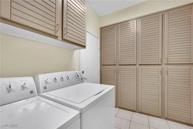 laundry area with light tile patterned flooring, cabinets, and washer and dryer