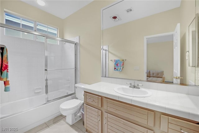 full bathroom with vanity, tile patterned flooring, shower / bath combination with glass door, and toilet