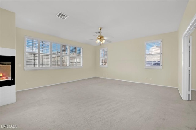 interior space with a tiled fireplace and ceiling fan