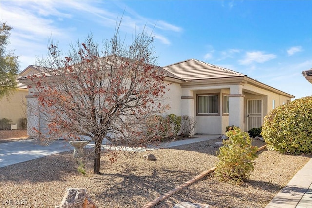 single story home featuring a tile roof, an attached garage, driveway, and stucco siding