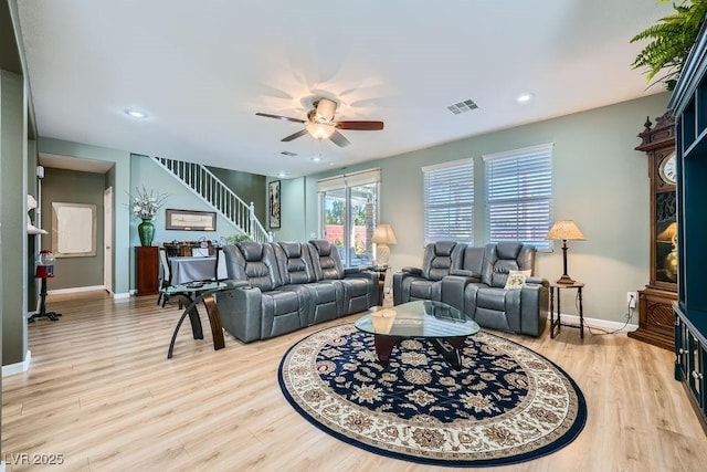 living room featuring ceiling fan and light hardwood / wood-style flooring