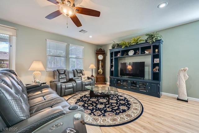 living room with ceiling fan, plenty of natural light, and light hardwood / wood-style flooring