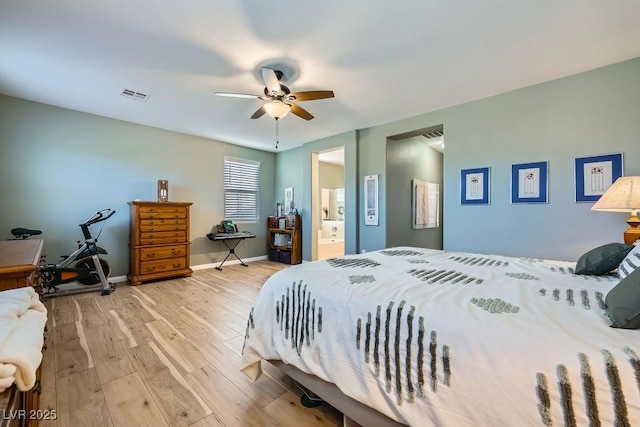 bedroom with light wood-type flooring, ceiling fan, and ensuite bathroom