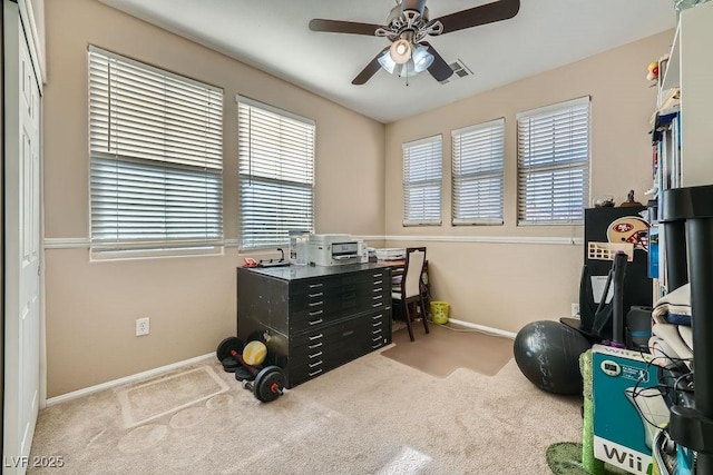 carpeted office space with ceiling fan