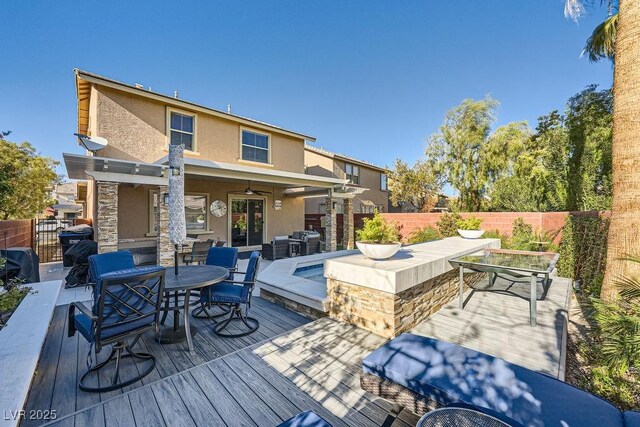 wooden terrace with ceiling fan, an outdoor bar, and area for grilling