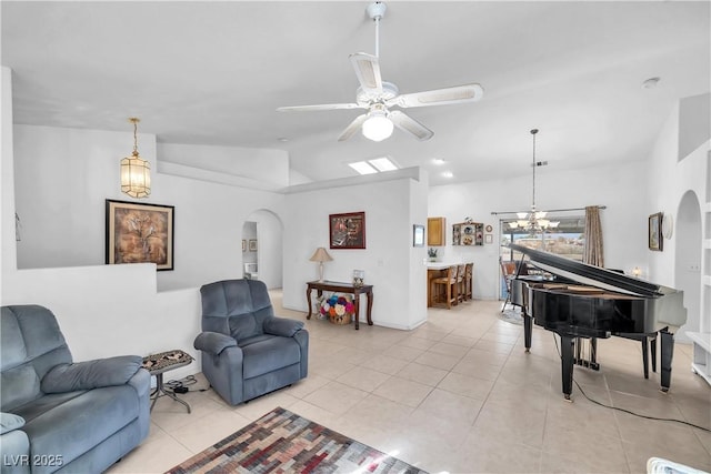 living room with vaulted ceiling, light tile patterned floors, and ceiling fan with notable chandelier