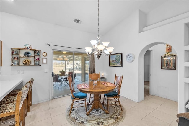 tiled dining room featuring lofted ceiling and an inviting chandelier