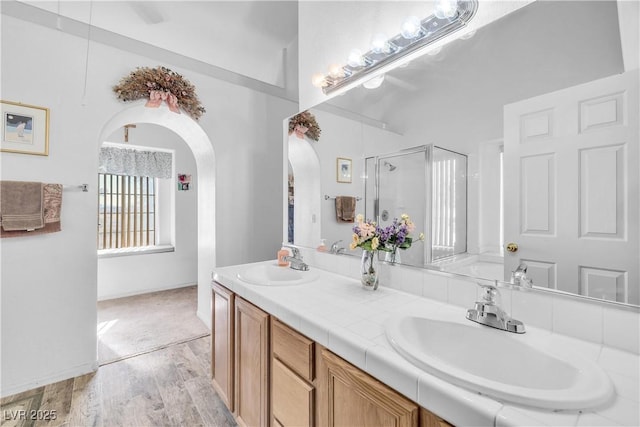 bathroom with walk in shower, vanity, and hardwood / wood-style floors