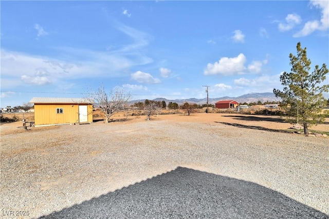 view of yard with a rural view and a mountain view