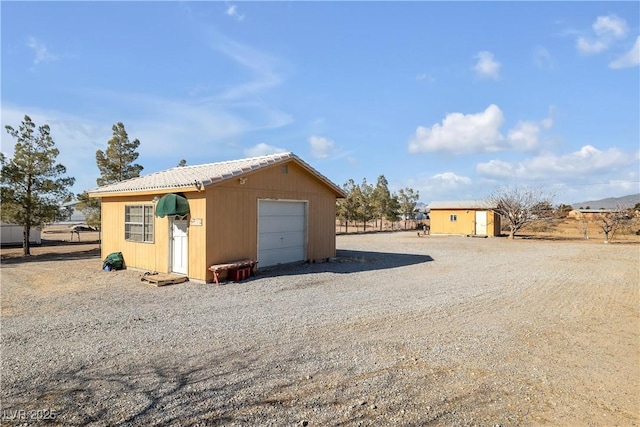 view of side of property with a garage and an outbuilding