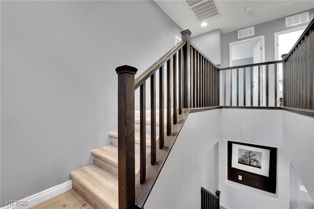 staircase with hardwood / wood-style floors