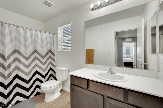 bathroom featuring toilet, wood-type flooring, and vanity