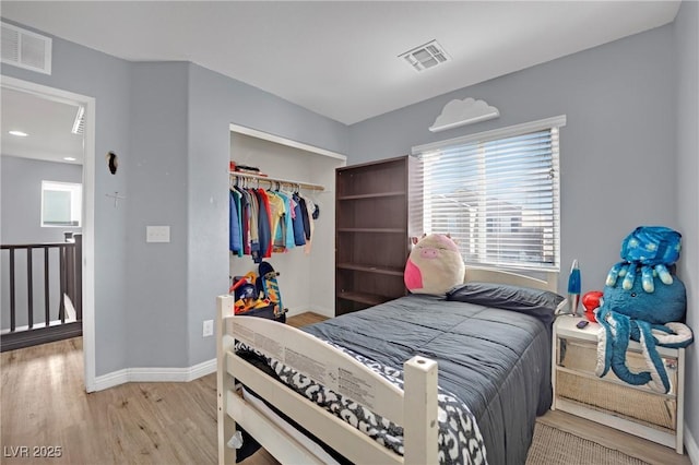 bedroom with light hardwood / wood-style floors and a closet