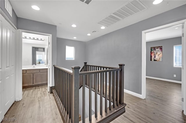 corridor with sink and light hardwood / wood-style flooring