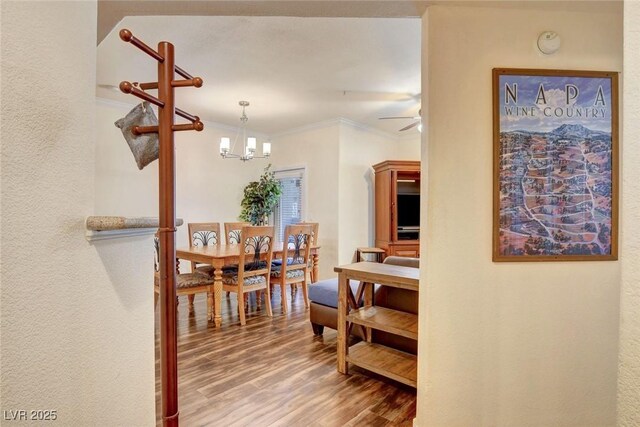 hall with a chandelier, crown molding, and hardwood / wood-style floors