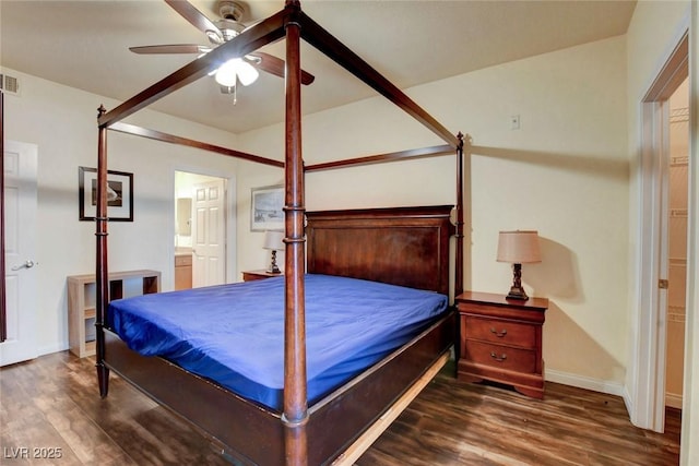 bedroom with dark wood-type flooring, ceiling fan, and ensuite bath