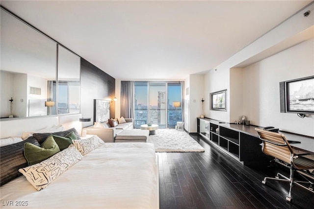 bedroom with a wall of windows and hardwood / wood-style floors