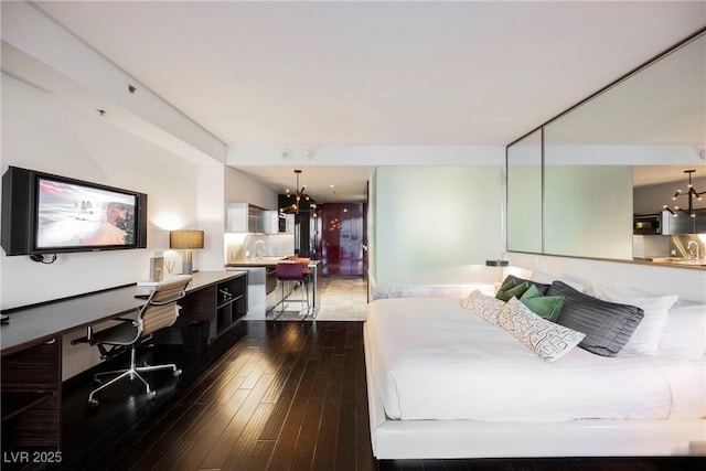 bedroom with dark hardwood / wood-style floors and an inviting chandelier