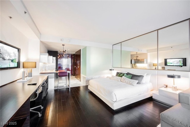 bedroom featuring a chandelier, dark hardwood / wood-style floors, and sink