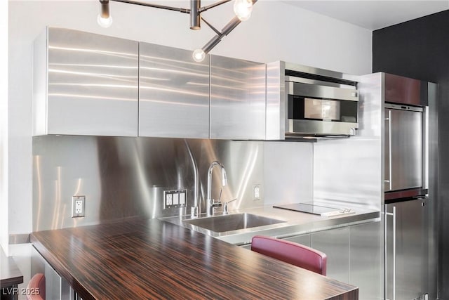 kitchen featuring stainless steel counters, sink, decorative backsplash, and appliances with stainless steel finishes