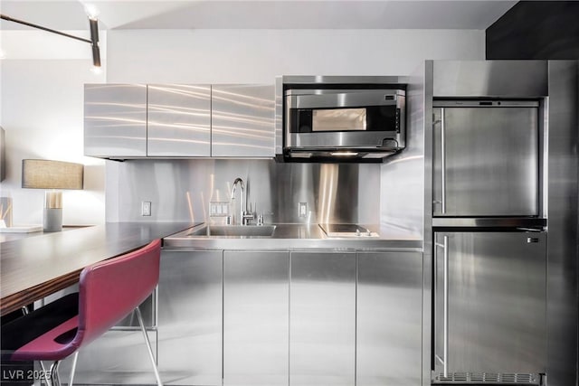 kitchen featuring stainless steel appliances, stainless steel counters, and sink