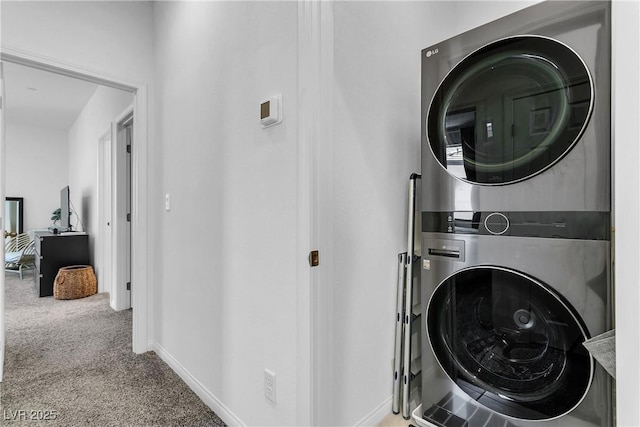 clothes washing area with stacked washer and dryer and light carpet